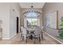 Formal dining room featuring a decorative chandelier, large window, and seating for six at 15237 S 19Th Way, Phoenix, AZ 85048