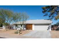 Ranch-style home with modern wood accents and landscaped yard at 1834 W Kerry Ln, Phoenix, AZ 85027