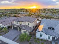 Luxury two-story home with landscaped yard, pool, and mountain views at sunset at 22034 N 59Th Pl, Phoenix, AZ 85054