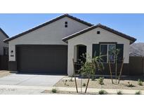 Charming single-story home featuring neutral stucco, a dark brown garage door, and desert landscaping at 22319 W Monona Ln, Surprise, AZ 85387