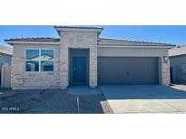 Charming single-story home featuring stone accents, a two-car garage and a well-maintained desert landscape at 25359 W Sunland Ave, Buckeye, AZ 85326