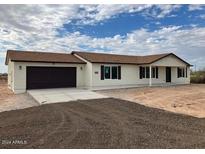 New single-story home with attached garage, neutral exterior, and desert landscaping at 25603 W Hedgehog Rd, Wittmann, AZ 85361