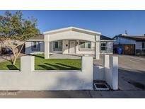 Newly renovated home with a modern facade and well-manicured lawn at 8230 W Monterey Way, Phoenix, AZ 85033