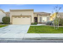 Beige one-story house with a two-car garage and well-manicured lawn at 8383 W Utopia N Rd, Peoria, AZ 85382