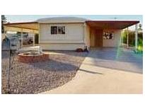 Mobile home exterior with carport and gravel driveway at 8627 E Dulciana Ave # 43, Mesa, AZ 85208