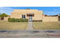 Tan stucco house with a tiled entryway and well-manicured lawn at 948 S Alma School Rd Rd # 89, Mesa, AZ 85210