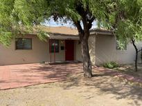 Ranch style home with red door and a spacious front patio at 1732 W Indian School Rd, Phoenix, AZ 85015
