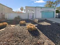 House exterior featuring a teal garage door and well-maintained landscaping at 1433 E Kerry Ln, Phoenix, AZ 85024