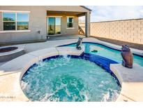 Relaxing backyard oasis with a spa and inviting pool at 40634 W Hillman Dr, Maricopa, AZ 85138