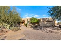 Desert landscape surrounds this one-story home with stucco exterior and attached garage at 5743 E Windstone Trl, Cave Creek, AZ 85331