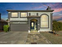 Two-story house with neutral color scheme and landscaped yard at 11020 W Lane Ave, Glendale, AZ 85307