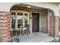 Inviting front porch with brick columns, wrought iron chairs, and a welcoming entrance at 1233 E Monte Vista Rd, Phoenix, AZ 85006