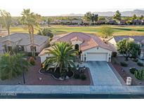 Single-story home with tile roof, palm trees, and a view of a golf course at 3604 N 162Nd Ave, Goodyear, AZ 85395