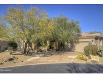 Single-story home with desert landscaping and a large driveway at 7546 E High Point Dr, Scottsdale, AZ 85266