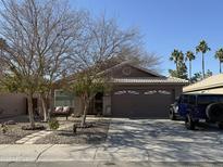 One-story house with a two-car garage, desert landscaping, and a blue Jeep parked in the driveway at 1916 S Oak St, Gilbert, AZ 85233