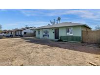 Ranch style home with a large front yard and a green brick facade at 3821 W Verde Ln, Phoenix, AZ 85019