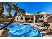 Inviting backyard oasis featuring a sparkling pool, patio furniture, and lush landscaping at 4795 E Bellerive Dr, Chandler, AZ 85249