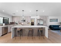 Modern kitchen with island, stainless steel appliances, and light wood cabinets at 5717 E Justine Rd, Scottsdale, AZ 85254