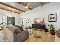 Open living space with hardwood floors, a large TV, and comfortable seating at 8008 E Del Rubi Dr, Scottsdale, AZ 85258