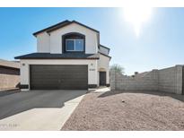 Two-story house with a brown garage door and a gravel driveway at 9089 W Troy Dr, Arizona City, AZ 85123