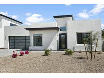 Modern stucco home with a two-car garage and landscaped front yard at 100 W Northern Ave # 16, Phoenix, AZ 85021