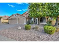 Tan two-story house with three-car garage and desert landscaping at 20961 N 96Th Dr, Peoria, AZ 85382