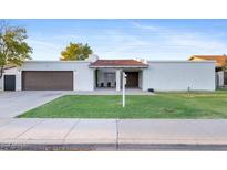 Single-story home with attached garage and well-manicured lawn at 3828 E Covina St, Mesa, AZ 85205