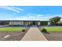 Single story home with landscaped lawn and walkway at 4901 W Soft Wind Dr, Glendale, AZ 85310