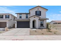 Charming two-story home featuring a two-car garage, landscaped front yard, and stylish architectural details at 7416 S 76Th Ln, Laveen, AZ 85339