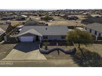 Single story home with landscaped front yard, large driveway and RV parking at 8547 W Magnum Dr, Arizona City, AZ 85123