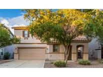 Two-story house with tan exterior, landscaped yard, and two-car garage at 1174 E Canyon Creek Dr, Gilbert, AZ 85295