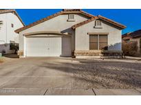 One-story home with a white garage door and stone accents at 12810 W Edgemont Ave, Avondale, AZ 85392