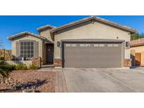 Charming single-story home featuring a two-car garage and low maintenance desert landscaping at 1814 W Desert Spring Way, San Tan Valley, AZ 85144