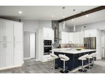 Modern kitchen with white cabinets, stainless steel appliances, central island, and stylish backsplash at 6102 E Nisbet Rd, Scottsdale, AZ 85254