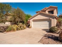 Two-story house with a tan exterior, attached garage, and desert landscaping at 6751 N 77Th Dr, Glendale, AZ 85303