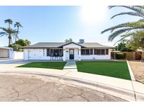 Charming mid-century home features a manicured lawn and updated facade at 8431 E Stella Ln, Scottsdale, AZ 85250