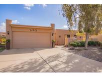 Two-car garage with tan doors and desert landscaping at 26209 S Greencastle Dr, Sun Lakes, AZ 85248