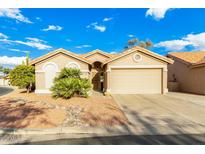 Single-story house with tan exterior, two-car garage, and desert landscaping at 6601 S Oakmont Dr, Chandler, AZ 85249