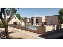 Community pool with lounge chairs and patio umbrellas at 1340 N Recker Rd # 243, Mesa, AZ 85205