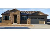 Inviting single-story home featuring a stone facade, shutters, and a two-car garage at 17990 W Fairview St, Goodyear, AZ 85338