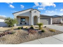 Single-story home with landscaped front yard, two-car garage, and inviting porch at 26330 W Kimberly Way, Buckeye, AZ 85396