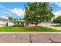 Charming home featuring a large tree, green lawn, and a classic white facade at 4525 E Calle Ventura --, Phoenix, AZ 85018