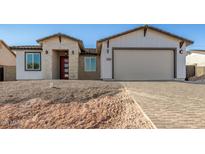 New construction home with brick and white exterior, two-car garage, and paver driveway at 6208 S Eagle Pass Rd, Gold Canyon, AZ 85118