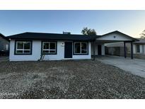 Modern single story home with dark gray roof and updated exterior at 7213 W Osborn Rd, Phoenix, AZ 85033