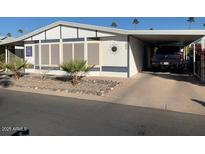 Single-wide manufactured home with carport and desert landscaping at 9302 E Broadway Rd # 103, Mesa, AZ 85208