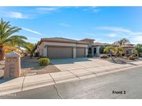 House exterior featuring a three-car garage and landscaped yard at 20621 N Canyon Whisper Dr, Surprise, AZ 85387