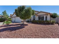 Charming front yard with mature trees and rock landscaping at 2705 E Verbena Dr, Phoenix, AZ 85048
