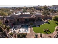 Luxury home with a large pool, grassy backyard, and expansive patio at 12824 E Jenan Dr, Scottsdale, AZ 85259