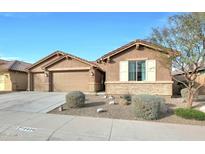 Tan two-story house with a three-car garage and landscaping at 18404 W Long Lake Rd, Goodyear, AZ 85338