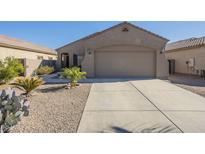 One-story house with a tan stucco exterior, two-car garage, and desert landscaping at 18509 N Toya St, Maricopa, AZ 85138